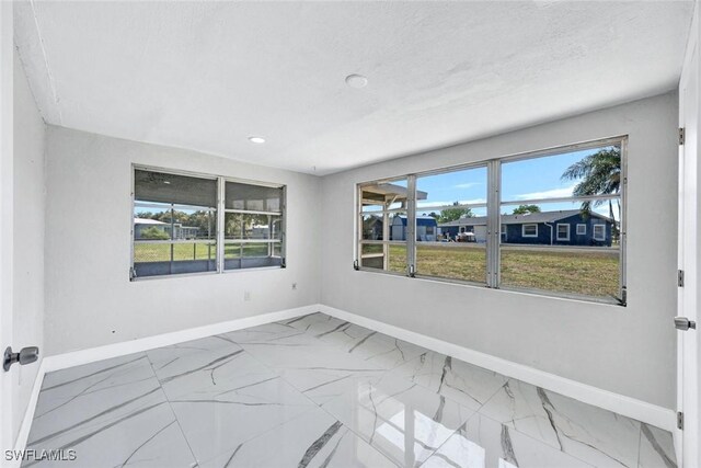 1423 Alwynne Dr, Lehigh Acres, FL 33936 - empty room featuring recessed lighting, marble finish floor, and baseboards