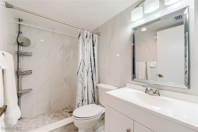 bathroom with vanity, toilet, and tiled shower