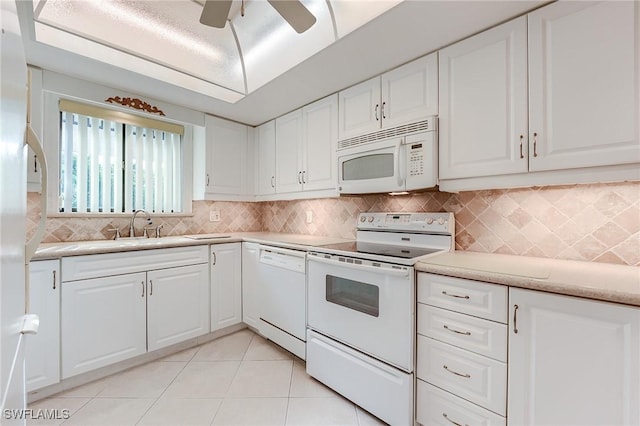 kitchen with white appliances, light countertops, white cabinetry, light tile patterned floors, and backsplash