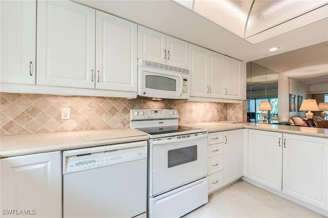 kitchen with light countertops, white cabinetry, decorative backsplash, and white appliances