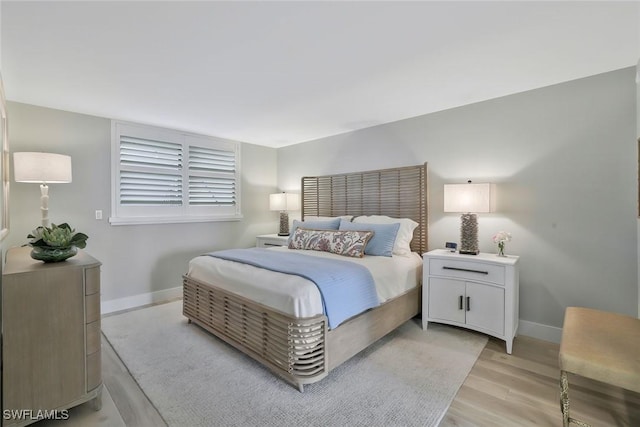 bedroom featuring light wood-style flooring and baseboards