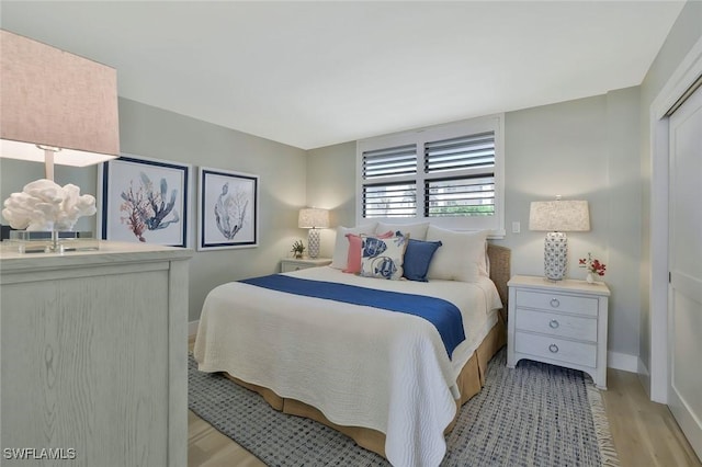 bedroom featuring baseboards and light wood finished floors