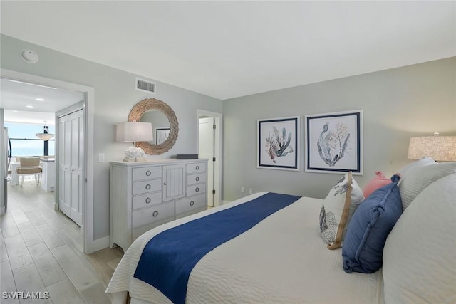 bedroom featuring baseboards, visible vents, and light wood-type flooring