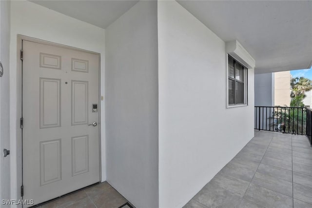 property entrance with a balcony and stucco siding