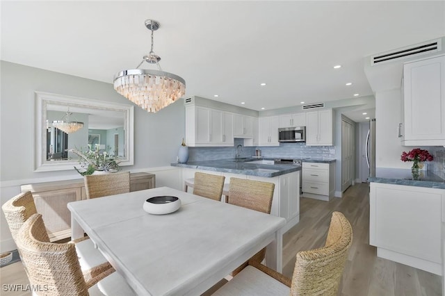 dining room with recessed lighting, light wood-style floors, a chandelier, and visible vents