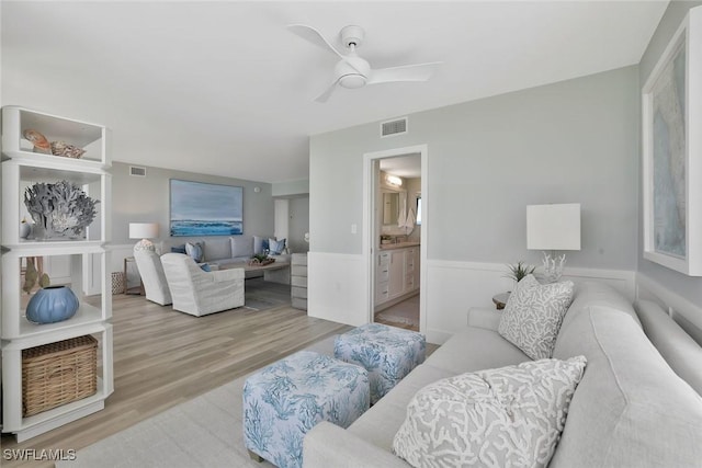 living room with wood finished floors, ceiling fan, and visible vents