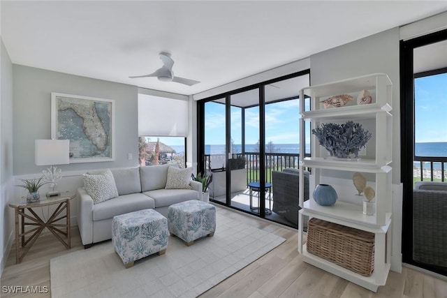 living room with floor to ceiling windows, ceiling fan, and wood finished floors