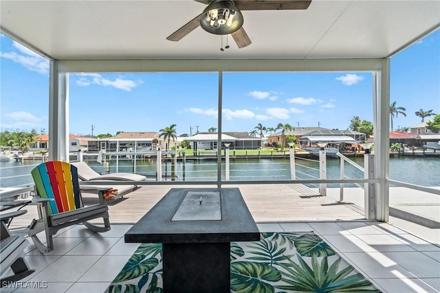view of patio / terrace with a water view, ceiling fan, and a dock