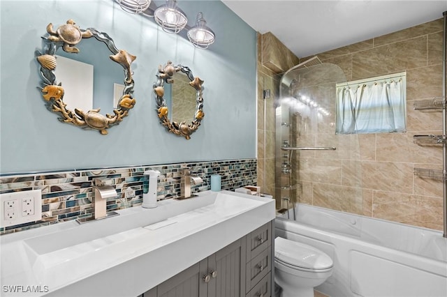 bathroom featuring decorative backsplash, toilet, shower / bathing tub combination, and vanity