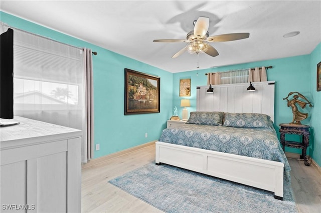 bedroom with baseboards, light wood-type flooring, and a ceiling fan