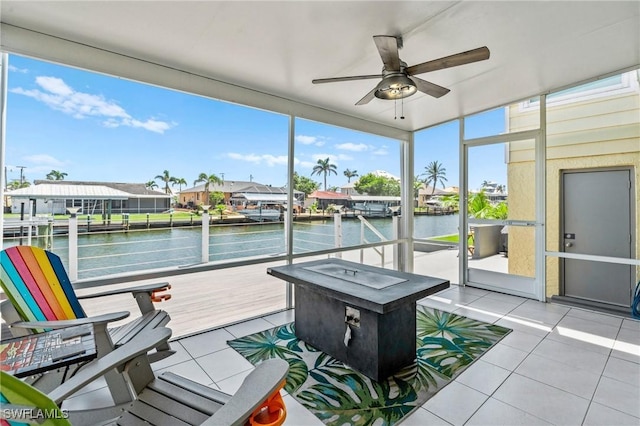 sunroom / solarium with a water view and ceiling fan