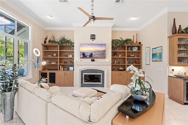 933 Barcarmil Way, Naples, FL 34110 - living area featuring crown molding, ceiling fan, a glass covered fireplace, visible vents, and light tile patterned flooring