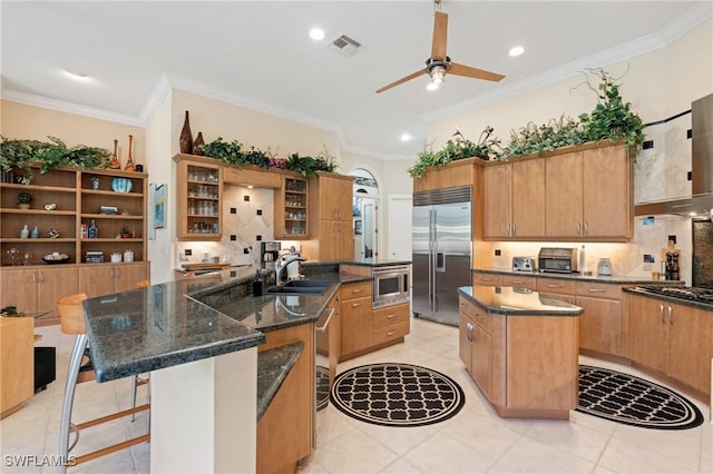933 Barcarmil Way, Naples, FL 34110 - kitchen with ornamental molding, visible vents, a center island, a sink, and built in appliances