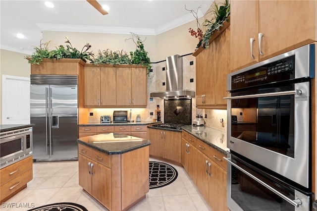 933 Barcarmil Way, Naples, FL 34110 - kitchen featuring crown molding, built in appliances, wall chimney exhaust hood, and backsplash