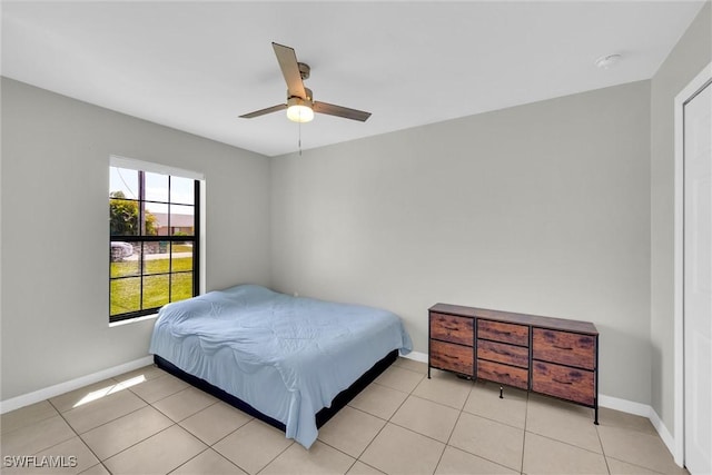 bedroom featuring light tile patterned flooring, baseboards, and ceiling fan