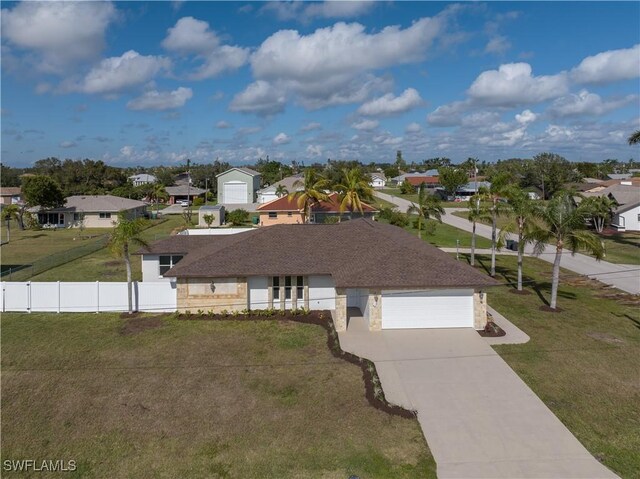 1725 SE 3rd St, Cape Coral, FL 33990 - view of front of home featuring a garage, fence, a front lawn, concrete driveway, and a residential view