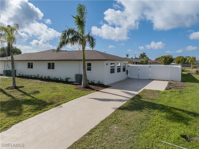 1725 SE 3rd St, Cape Coral, FL 33990 - single story home featuring a front yard, fence, cooling unit, stucco siding, and a gate