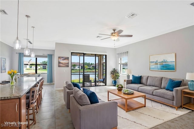 living area with a ceiling fan, a healthy amount of sunlight, and visible vents