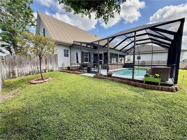 rear view of property featuring glass enclosure, metal roof, a fenced backyard, and a yard
