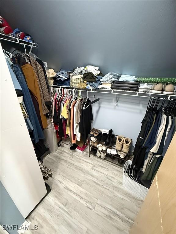 walk in closet with wood finished floors