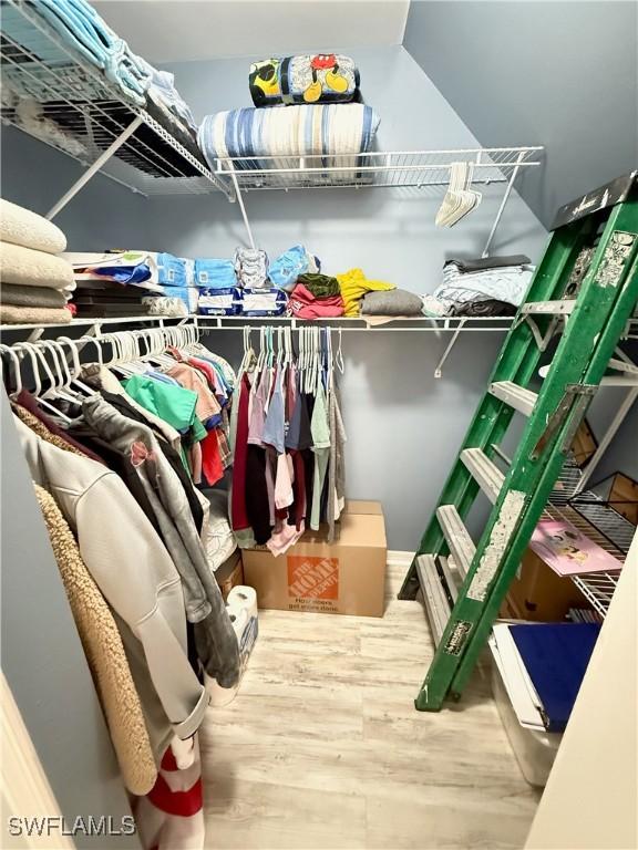 walk in closet with wood finished floors