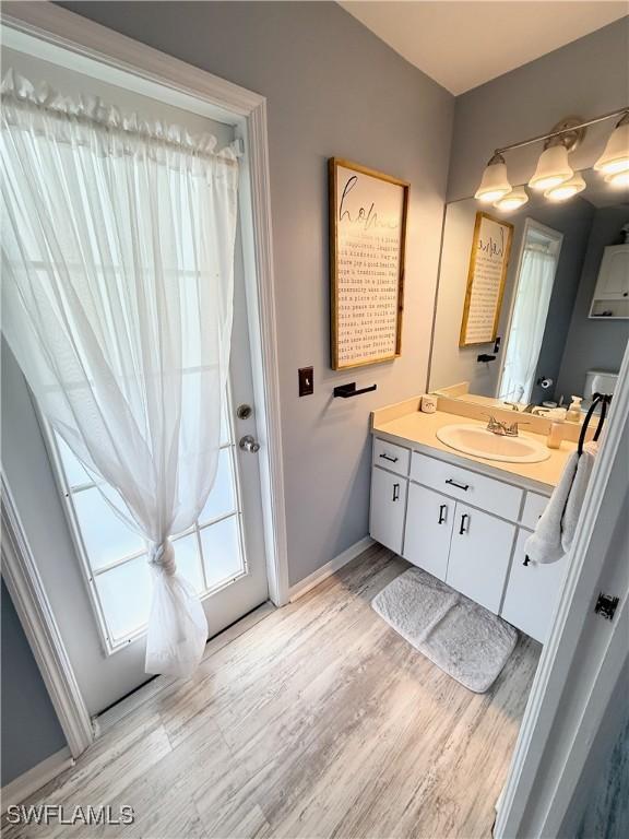 bathroom featuring vanity, baseboards, and wood finished floors