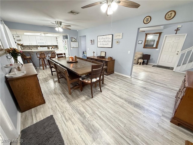 dining area featuring visible vents, light wood-style floors, and ceiling fan