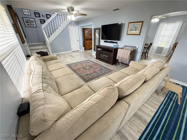 living room featuring ceiling fan, visible vents, and wood finished floors