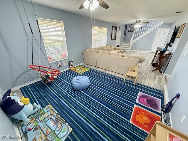 playroom with baseboards, visible vents, wood finished floors, and a ceiling fan