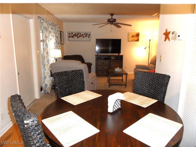 dining space with a ceiling fan and wood finished floors