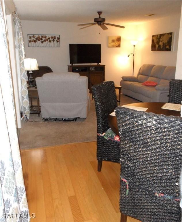living area with a ceiling fan and wood finished floors