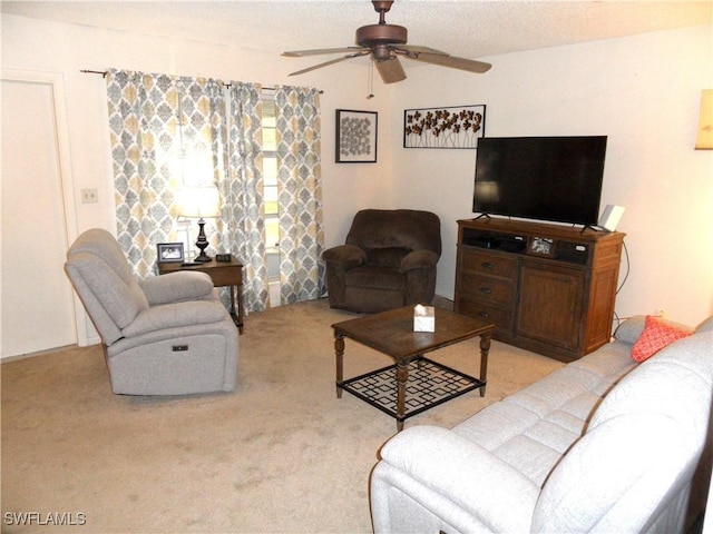living area with ceiling fan, carpet, and a textured ceiling