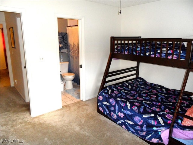 tiled bedroom with connected bathroom and carpet flooring