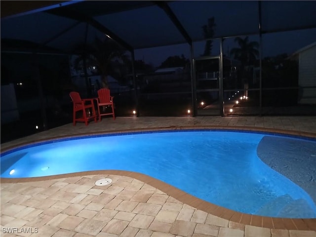 2138 Bahama Ave, Fort Myers, FL 33905 - pool at night featuring a patio, glass enclosure, and an outdoor pool
