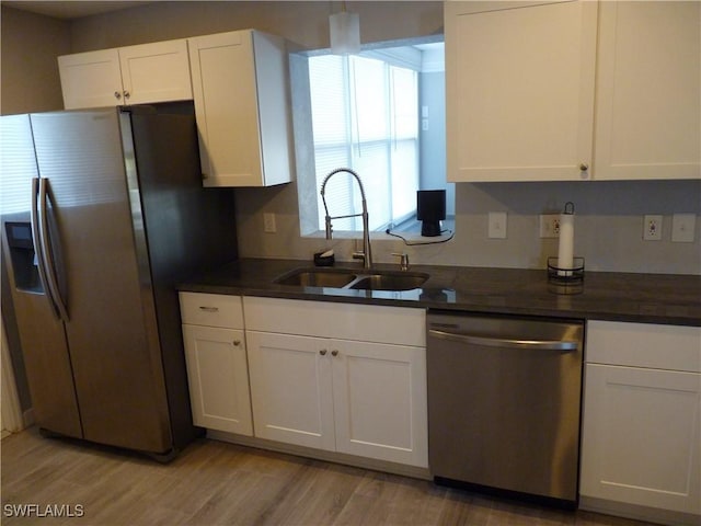 2138 Bahama Ave, Fort Myers, FL 33905 - kitchen featuring appliances with stainless steel finishes, a sink, dark countertops, white cabinetry, and light wood-style floors