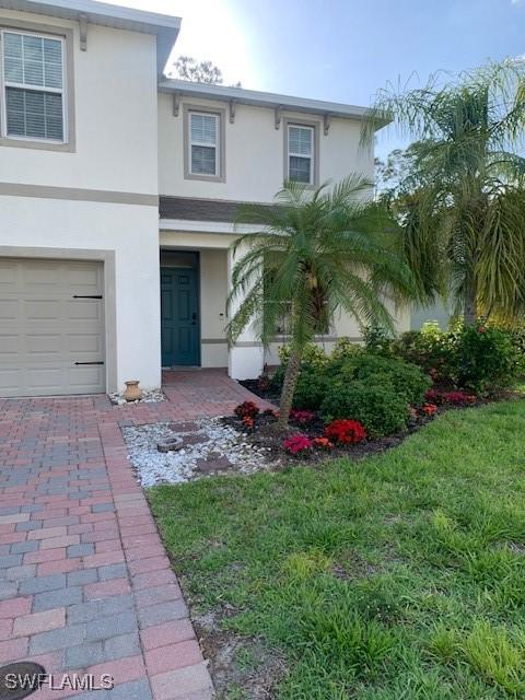 26974 Wildwood Pines Ln, Bonita Springs, FL 34135 - view of front facade featuring stucco siding and a garage
