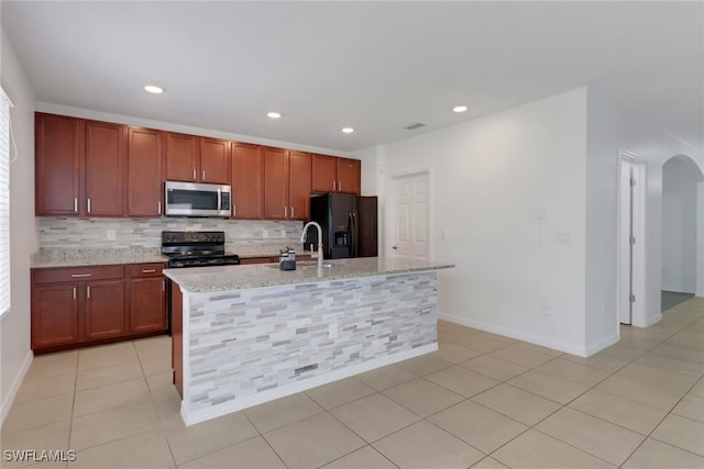 26974 Wildwood Pines Ln, Bonita Springs, FL 34135 - kitchen with black appliances, tasteful backsplash, arched walkways, an island with sink, and recessed lighting
