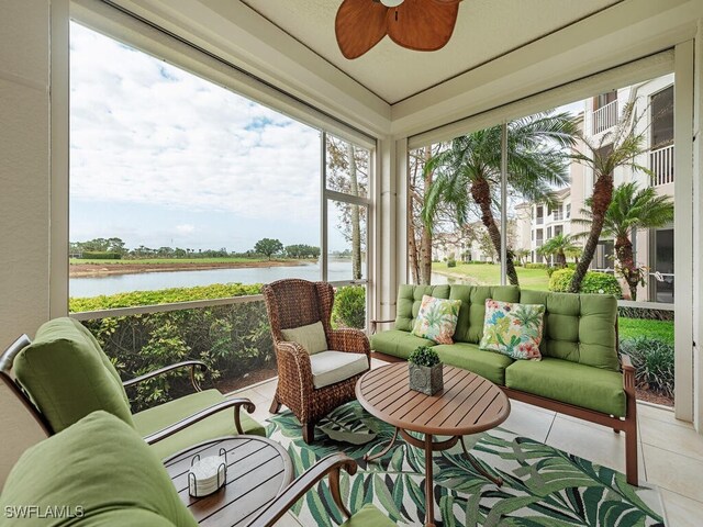 sunroom featuring a ceiling fan, a water view, and an outdoor living space