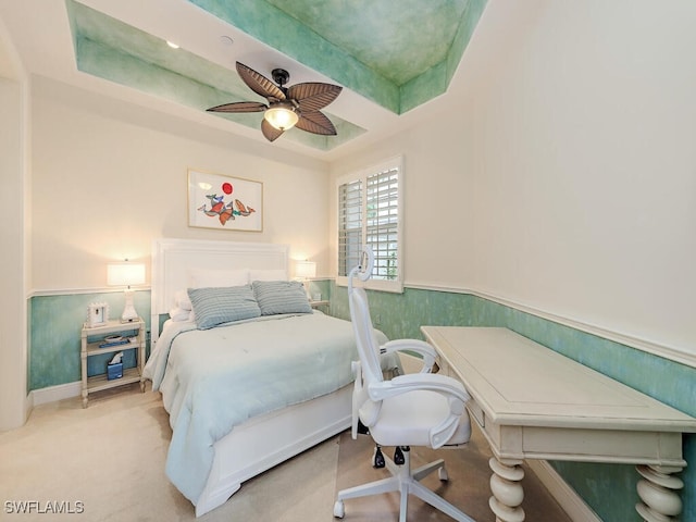 carpeted bedroom featuring wainscoting and a ceiling fan