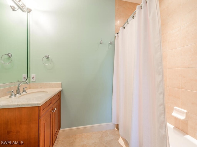 full bath featuring tile patterned floors, vanity, a shower with shower curtain, and baseboards