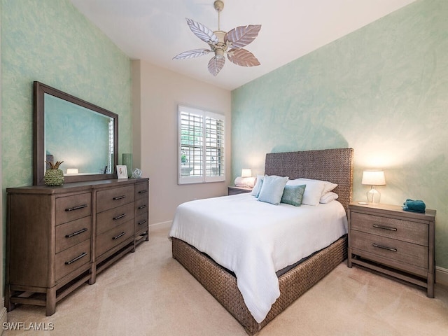bedroom featuring light colored carpet, ceiling fan, and baseboards