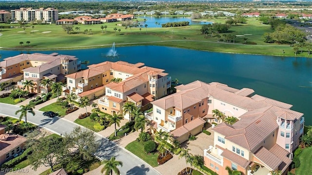 birds eye view of property with golf course view and a water view