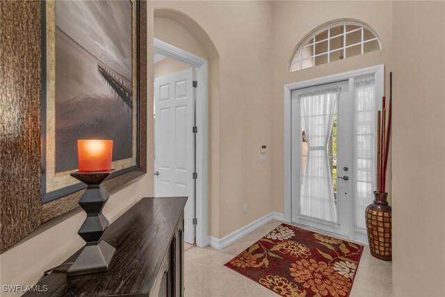6806 Bent Grass Dr, Naples, FL 34113 - foyer entrance featuring light tile patterned flooring, arched walkways, and baseboards