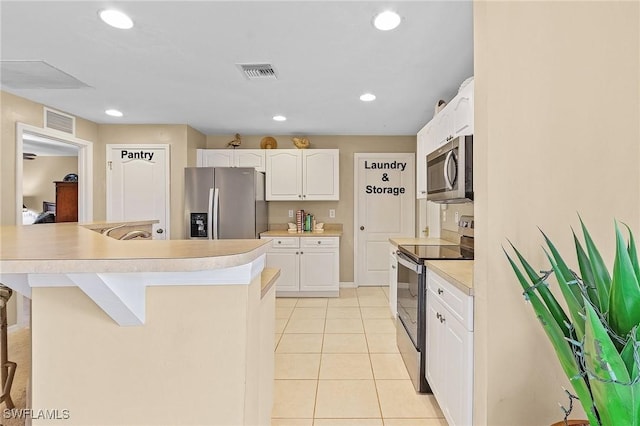 924 NE 11th Ave, Cape Coral, FL 33909 - kitchen featuring white cabinetry, visible vents, appliances with stainless steel finishes, and light tile patterned floors