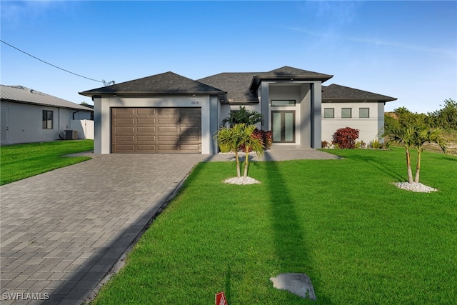 1412 SW 20th Ave, Cape Coral, FL 33991 - prairie-style home featuring stucco siding, an attached garage, decorative driveway, a front yard, and central AC