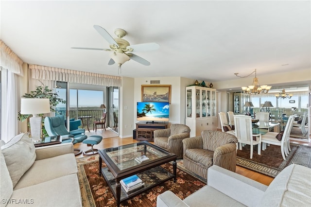 6361 Pelican Bay Blvd Unit 605, Naples, FL 34108 - living room featuring wood finished floors, ceiling fan with notable chandelier, and visible vents