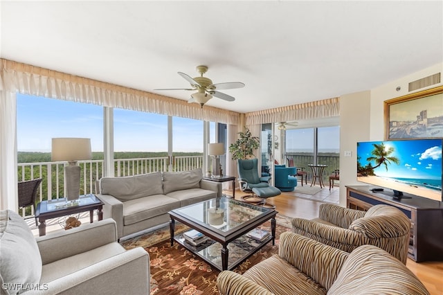 6361 Pelican Bay Blvd Unit 605, Naples, FL 34108 - living area featuring wood finished floors, a ceiling fan, visible vents, and plenty of natural light