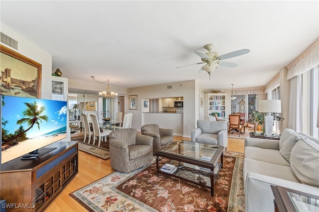 6361 Pelican Bay Blvd Unit 605, Naples, FL 34108 - living room featuring light wood-style floors, ceiling fan with notable chandelier, and visible vents