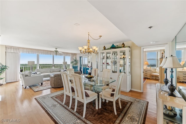 6361 Pelican Bay Blvd Unit 605, Naples, FL 34108 - dining area featuring light wood-style flooring and an inviting chandelier