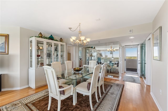 6361 Pelican Bay Blvd Unit 605, Naples, FL 34108 - dining room featuring a chandelier, light wood-style floors, and baseboards